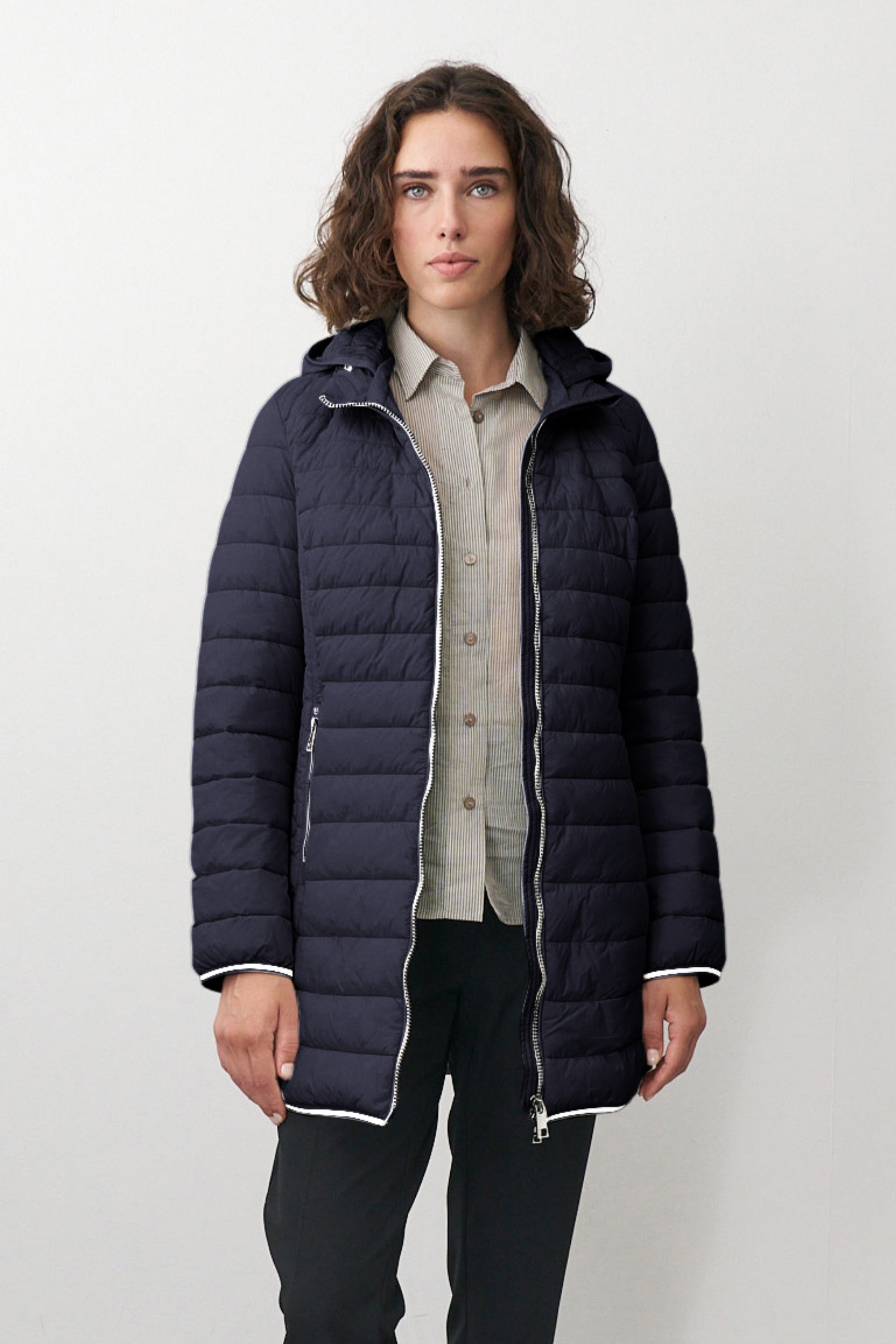 Lange Damen Steppjacke in Dunkelblau mit Kapuze und Stehkragen.