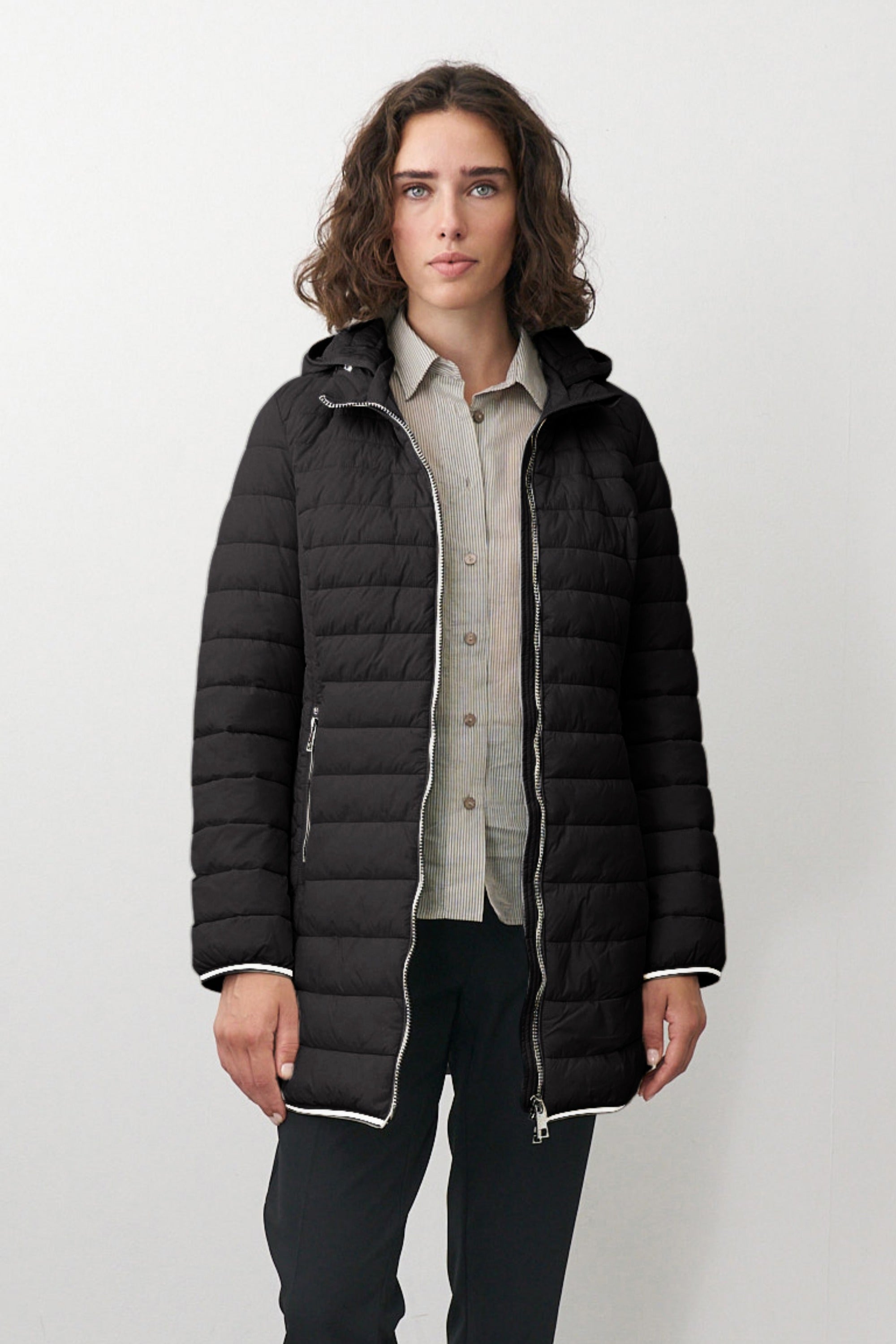 Lange Damen Steppjacke in Schwarz mit Kapuze und Stehkragen.