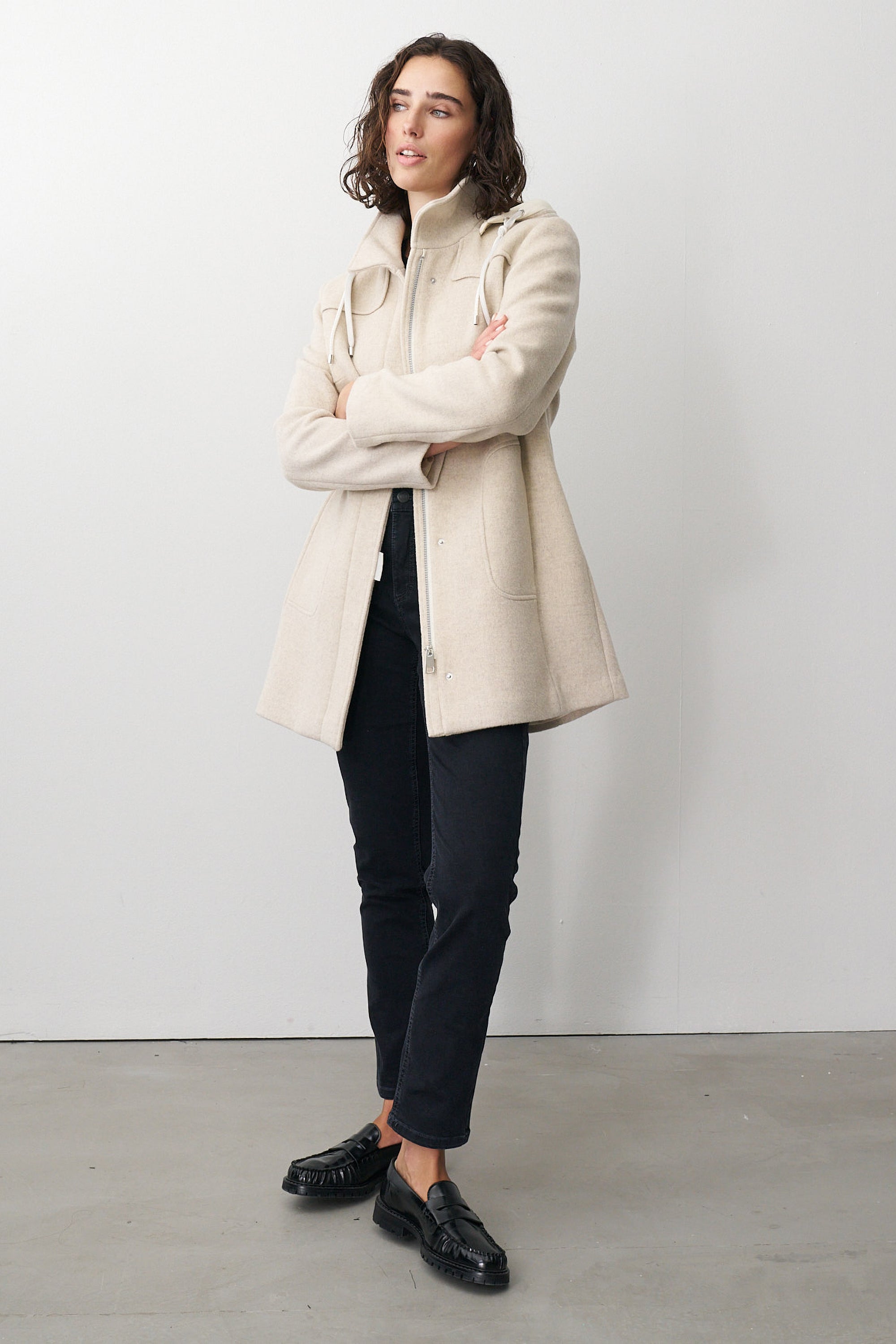 Damen Wolljacke in Beige mit Kapuze und Stehkragen.