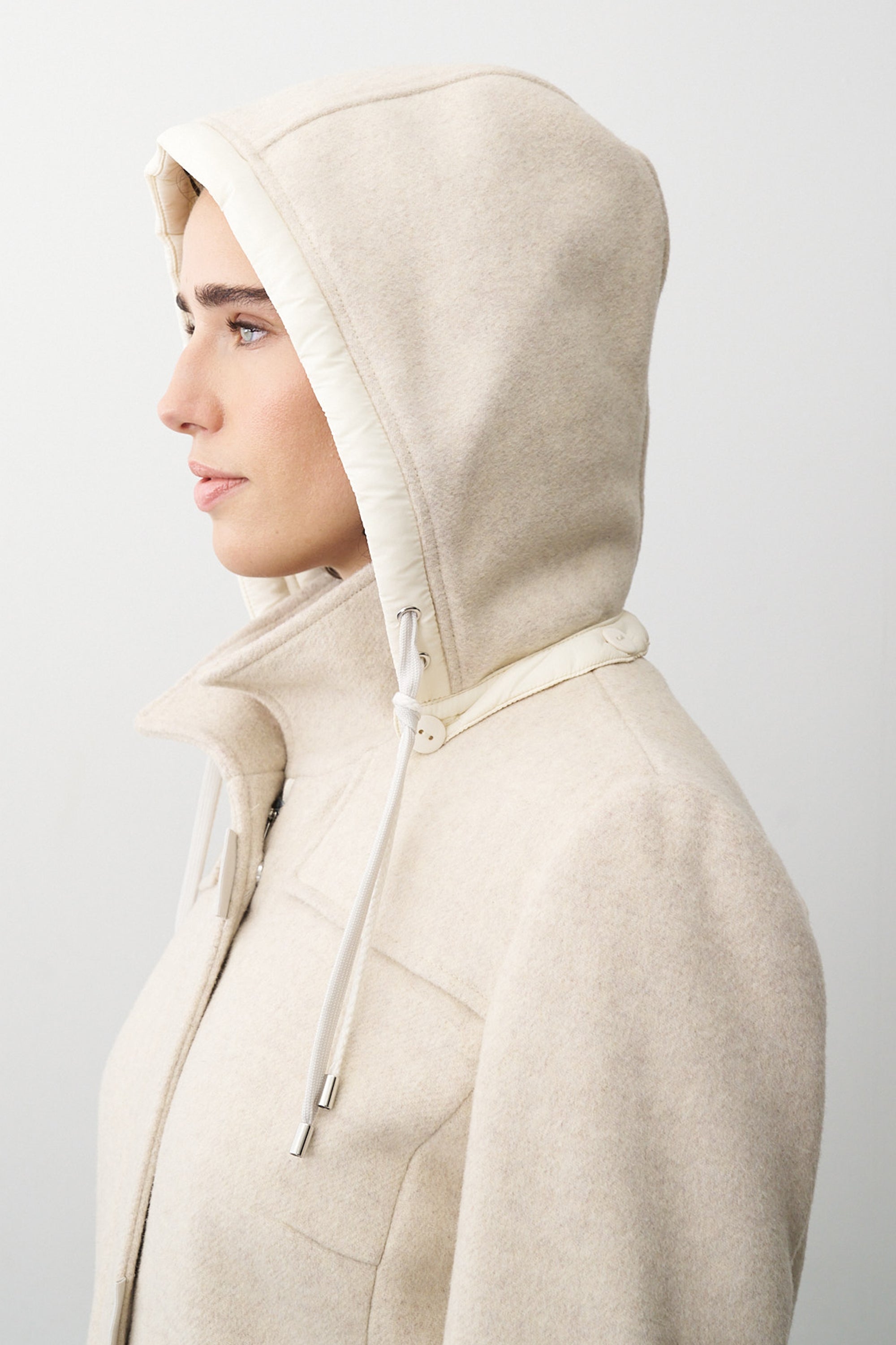 Damen Wolljacke in Beige mit Kapuze und Stehkragen.