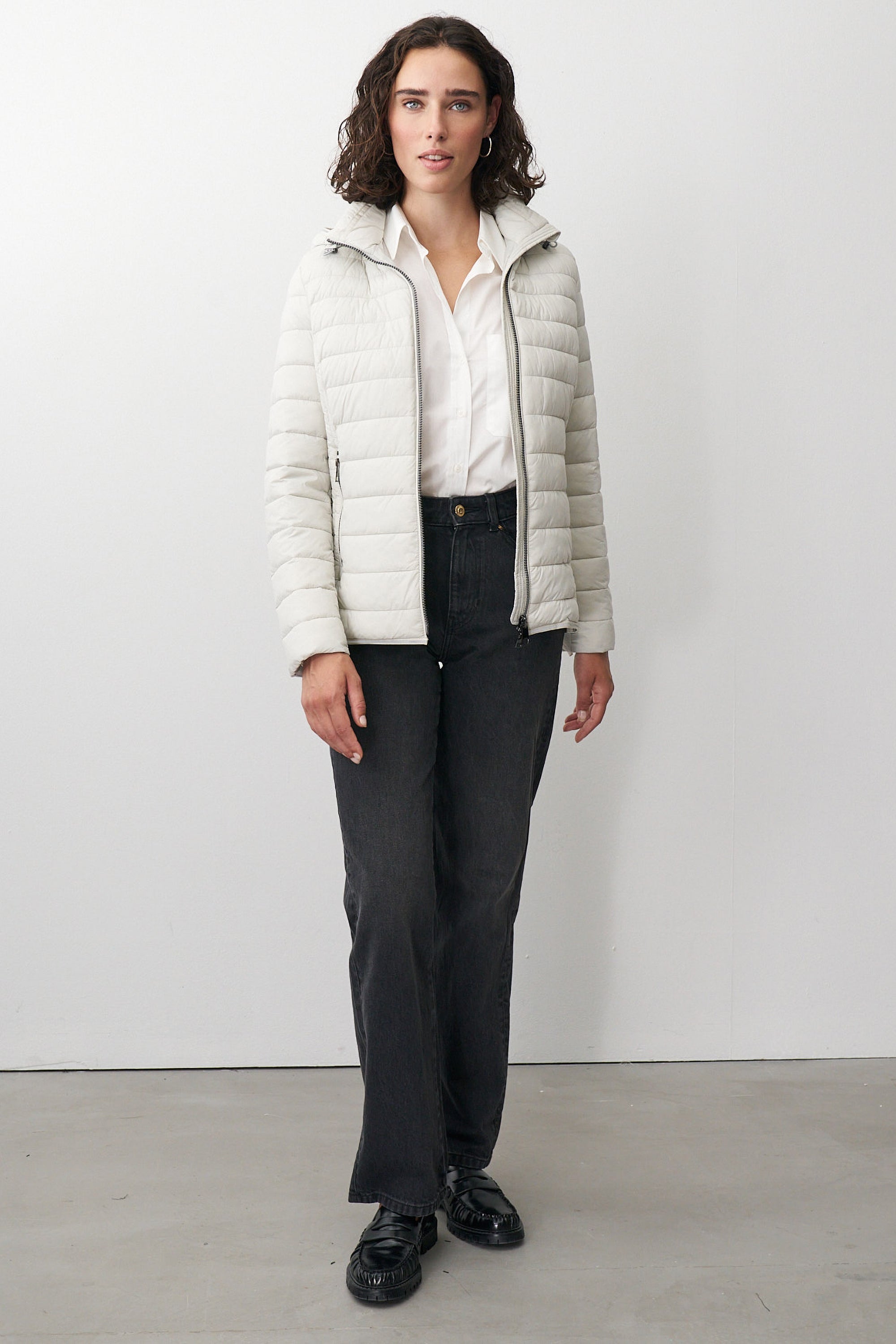 Damen Steppjacke in Beige mit Kapuze und Stehkragen.