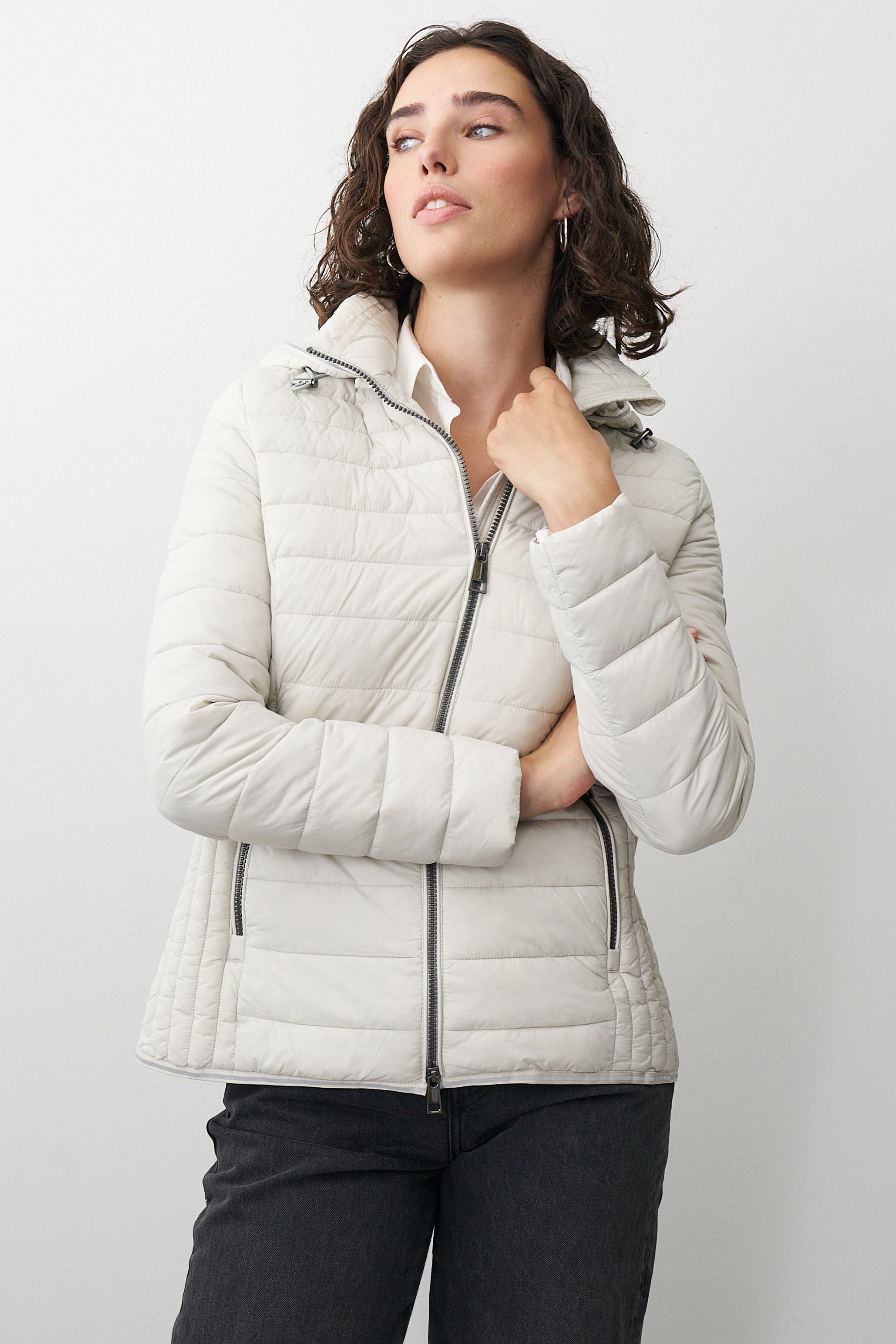 Damen Steppjacke in Beige mit Kapuze und Stehkragen.