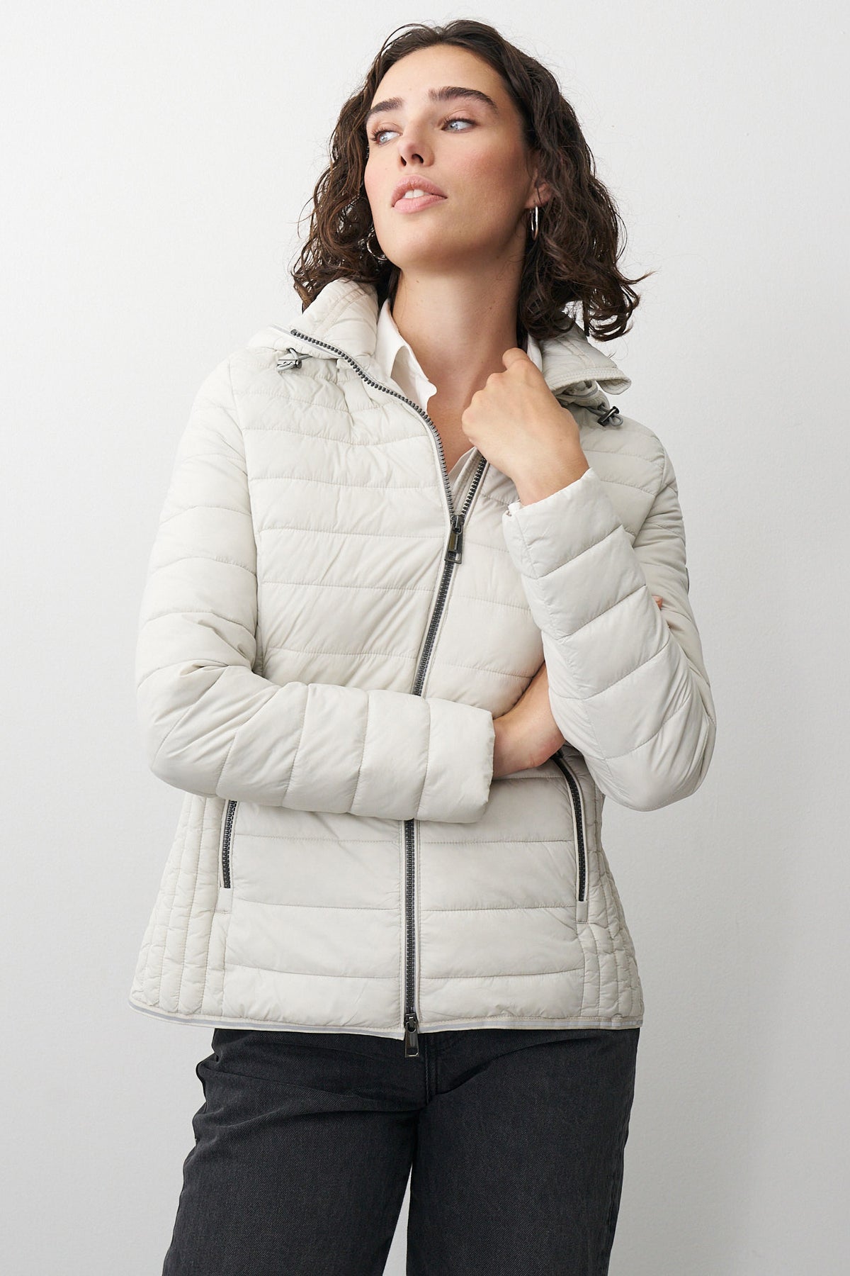 Damen Steppjacke in Beige mit Kapuze und Stehkragen.