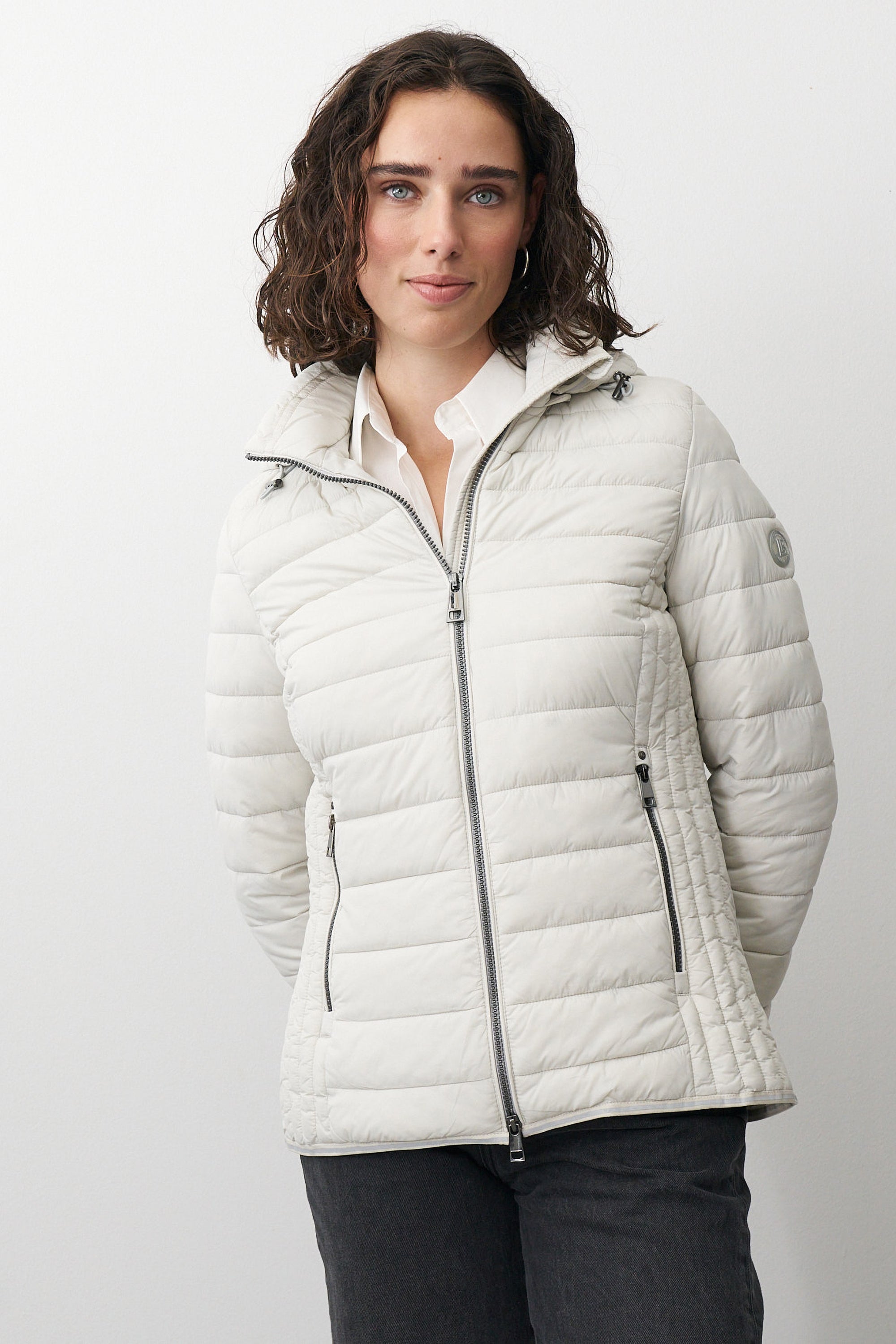 Damen Steppjacke in Beige mit Kapuze und Stehkragen.