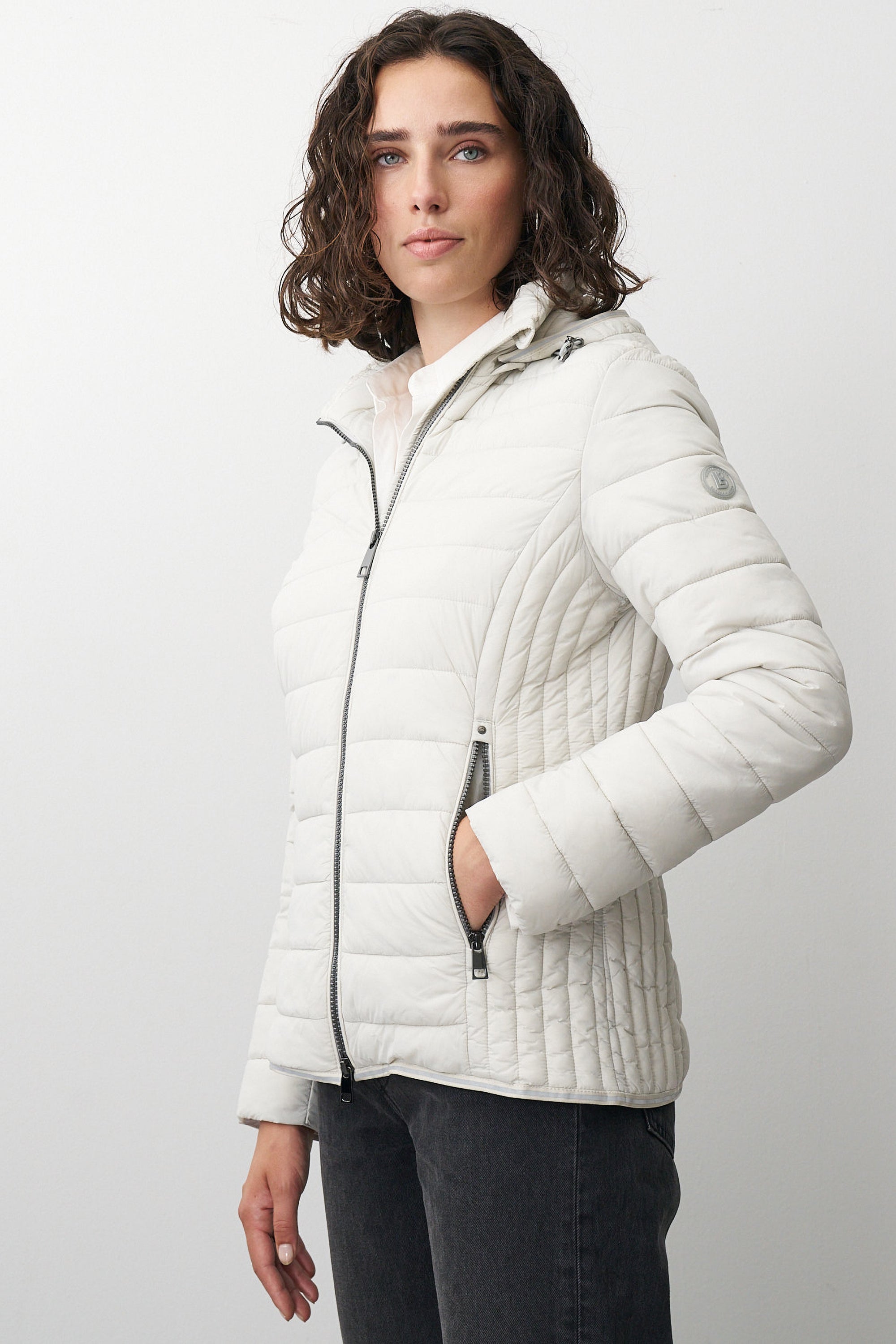 Damen Steppjacke in Beige mit Kapuze und Stehkragen.