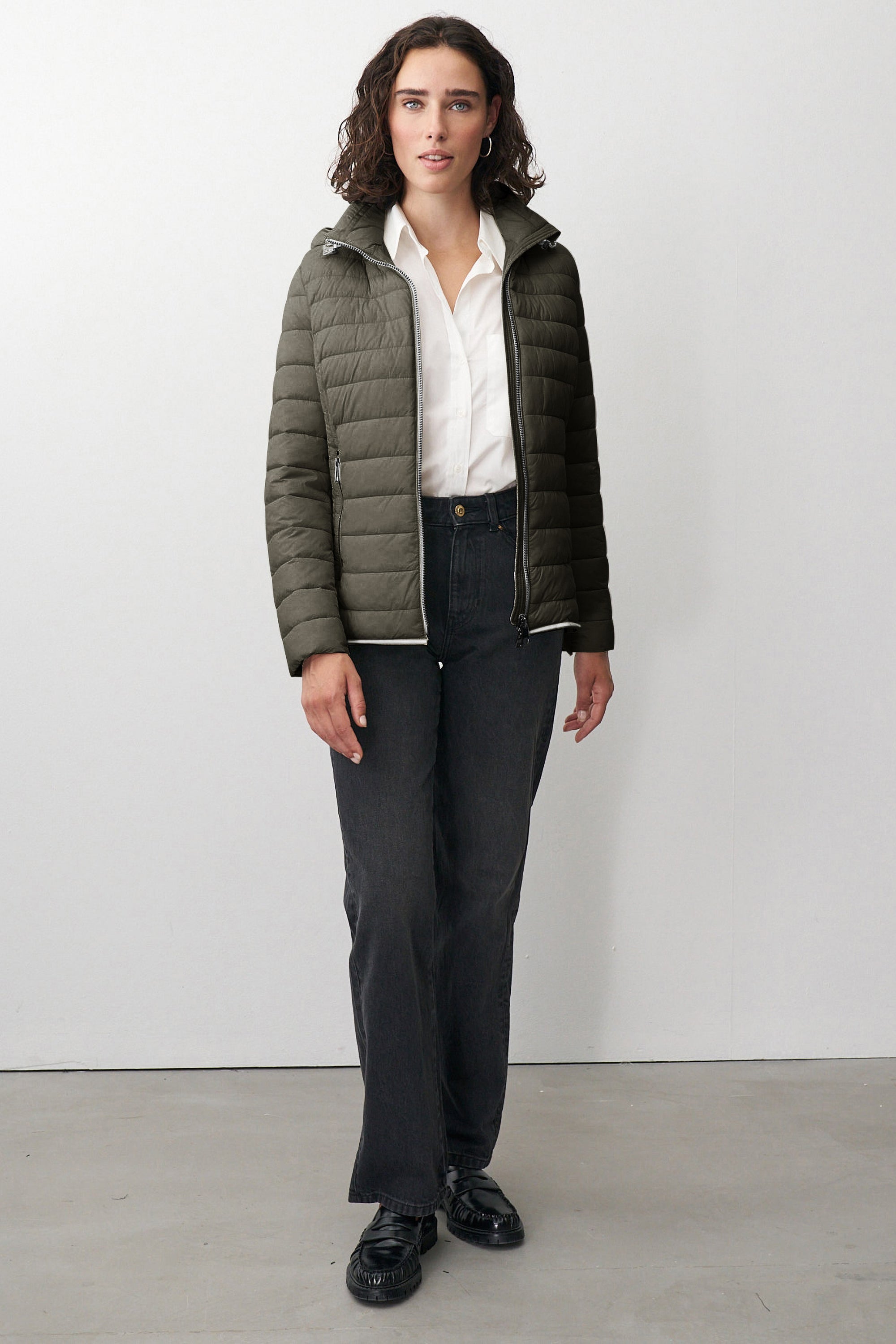 Damen Steppjacke in Grün mit Kapuze und Stehkragen.