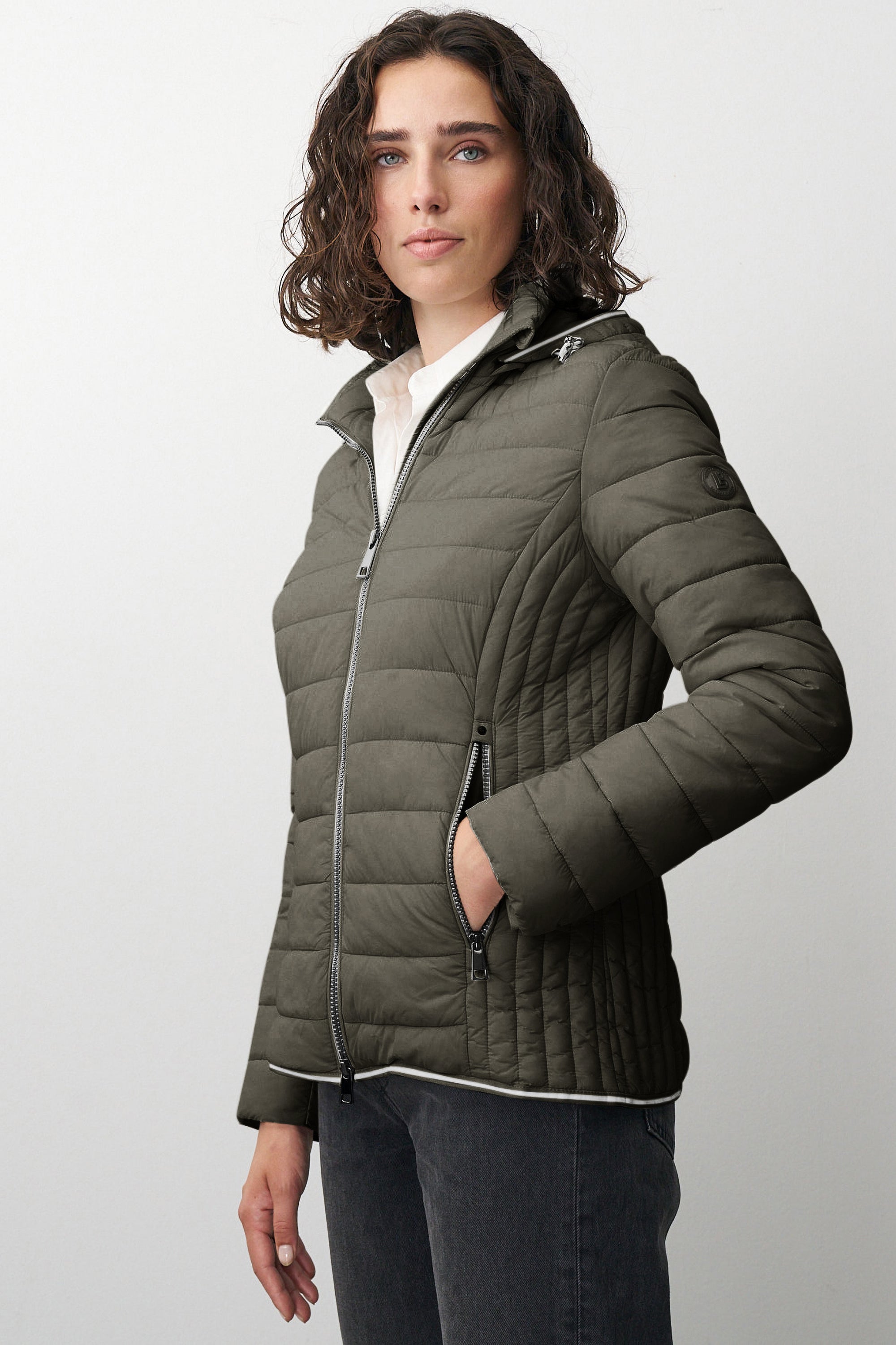 Damen Steppjacke in Grün mit Kapuze und Stehkragen.