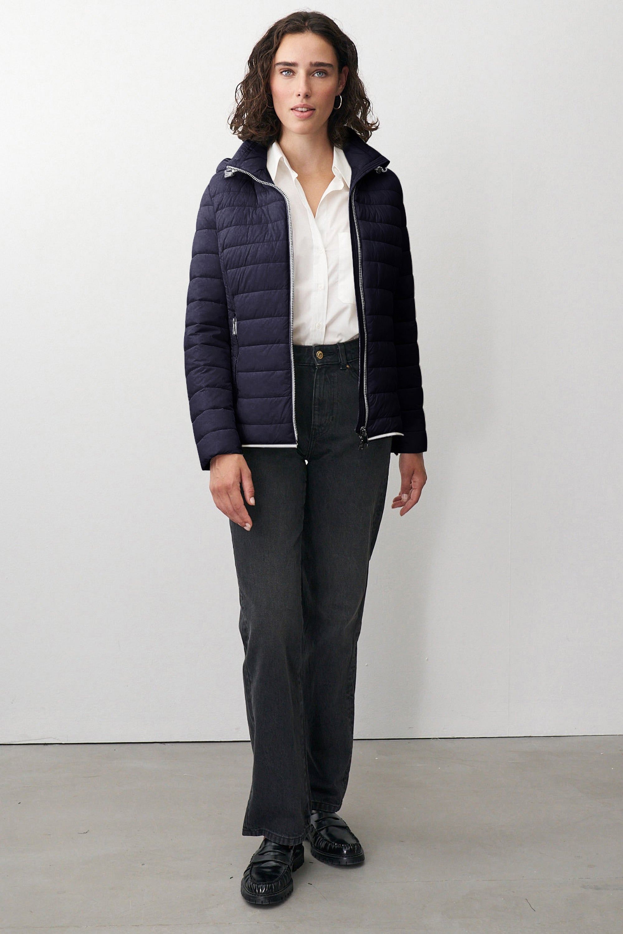 Damen Steppjacke in Dunkelblau mit Kapuze und Stehkragen.
